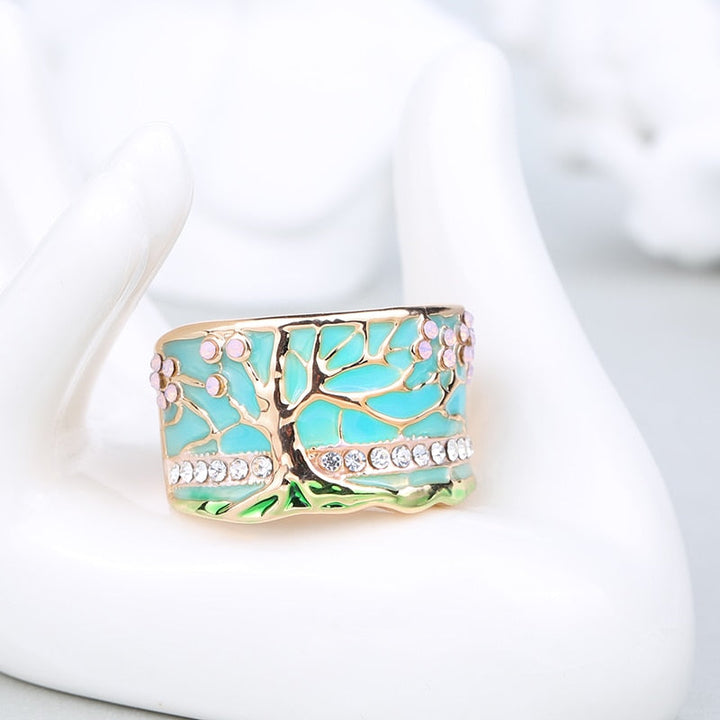 Närbild på symbolisk damring, Livets träd-design med skimrande opal som centrum. En elegant gåva.