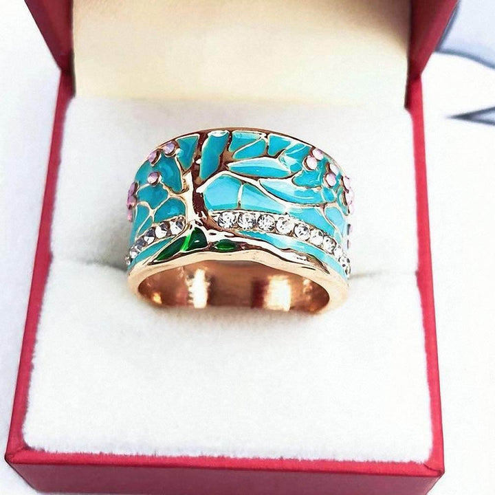 Vacker damring i allergivänlig legering, Lyckoträd-motiv med opal. Smycke som symboliserar liv och skönhet.