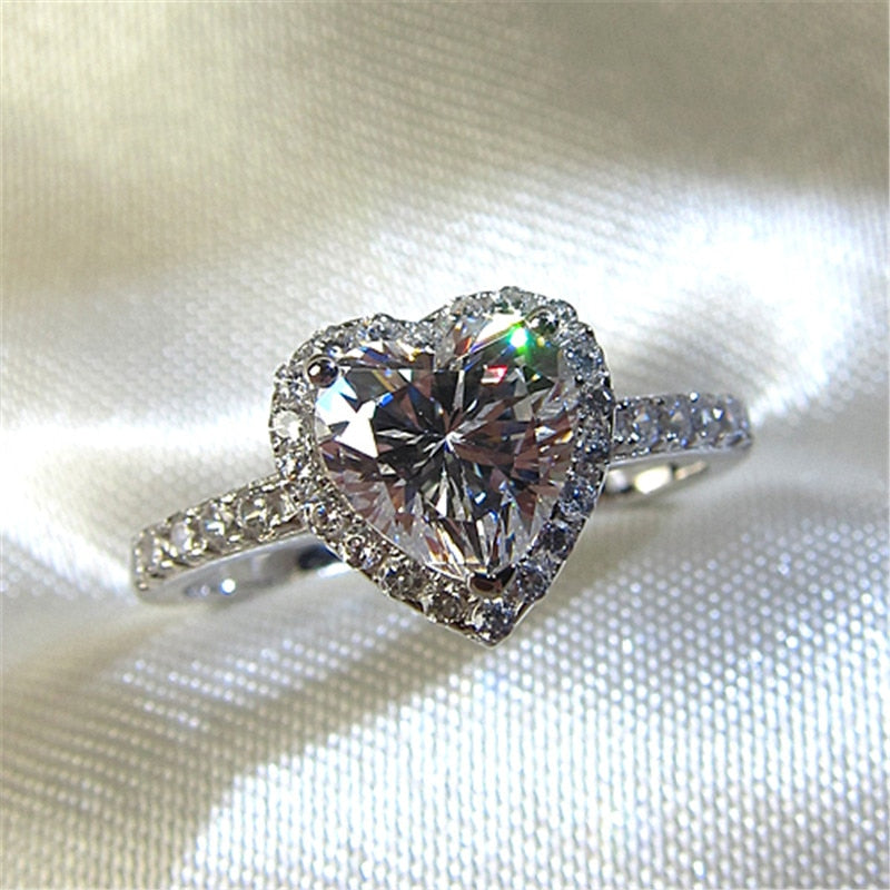 Närbild på sterling silver damring, gnistrande hjärta cubic zirconia, vigselring.