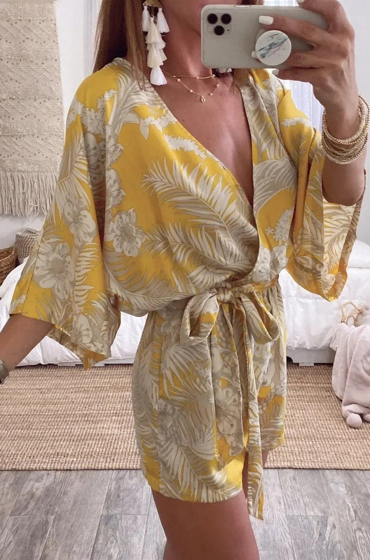 Kvinnlig sommarromper med djup V-ringning, långa ärmar och korta ben. Elegant och avslappnad.