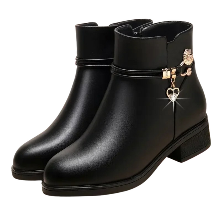 Närbild på strassutsmyckning på varma damchelseaboots i läderstil för vinterbruk.