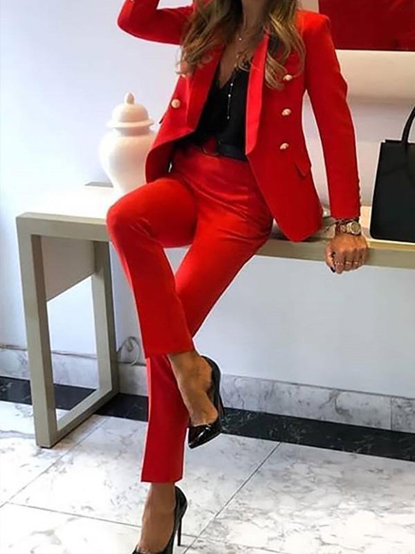 Modern dubbelknäppt kvinnors kostym med elegant kavaj och byxor. Idealiska affärskläder för formella event.
