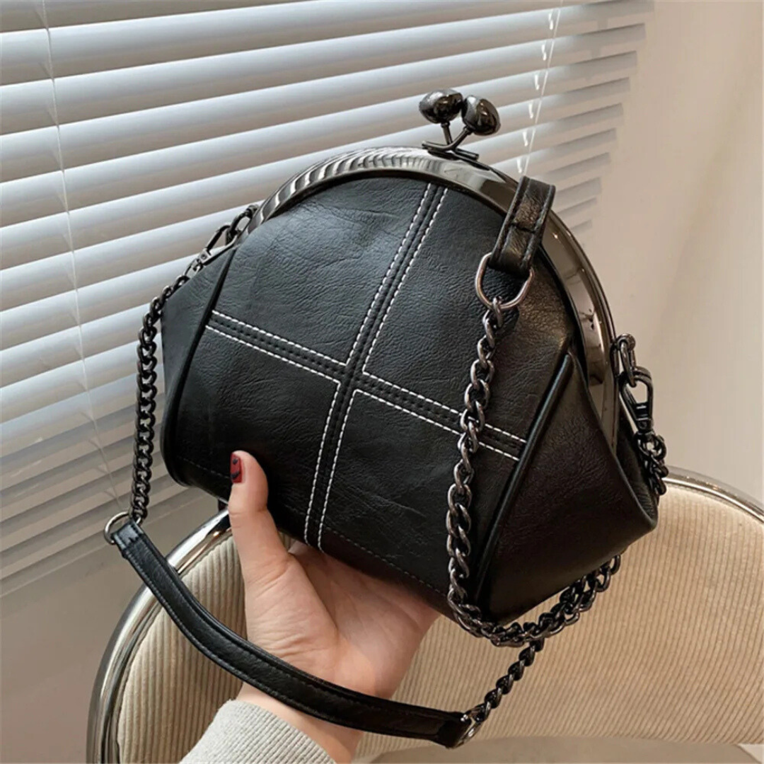 Kompakt och stilren kvinnors handväska med elegant design och praktisk kedjedetalj. Perfekt modeaccessoar.