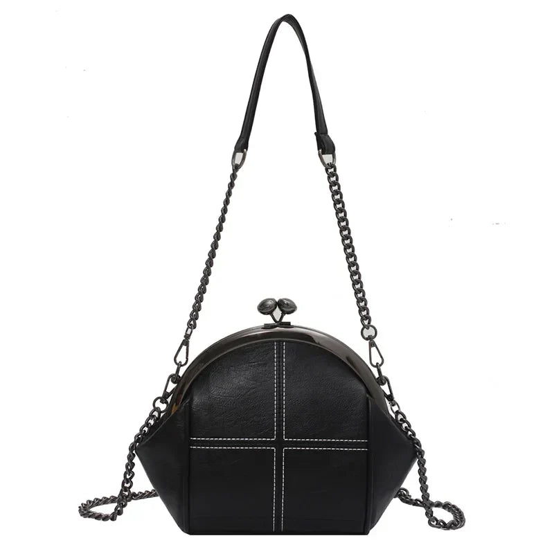 Detaljbild av elegant crossbody väska med glänsande kedjedetalj och slät finish. Mångsidig festväska.