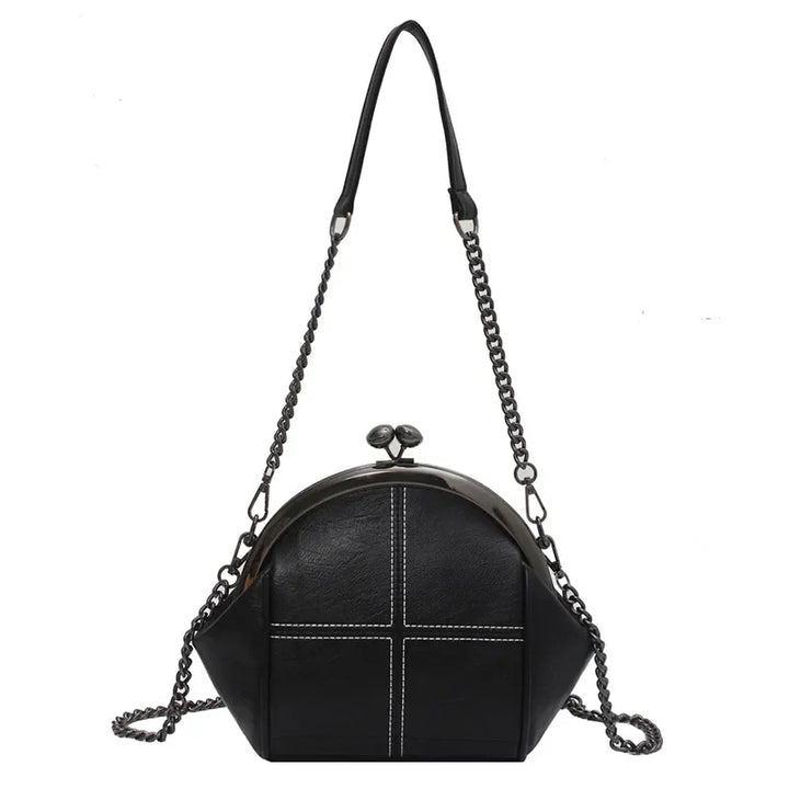 Detaljbild av elegant crossbody väska med glänsande kedjedetalj och slät finish. Mångsidig festväska.