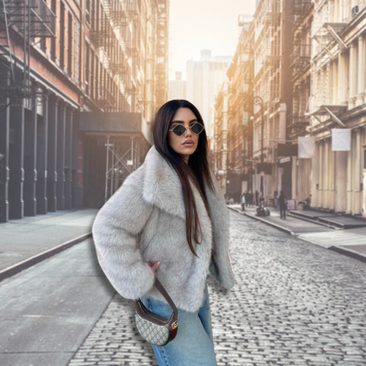 Kvinna bär stilfull, oversized fuskpälsjacka. Elegant damjacka, varmt ytterplagg för modeinriktade vinterdagar.