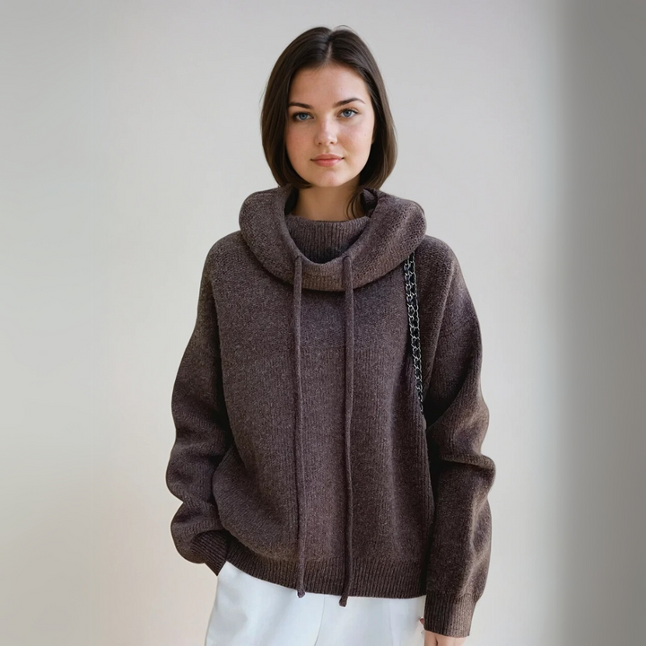 Detaljbild av den höga kragen på en elegant grå damtröja i stickad turtleneck-stil, vintermode.