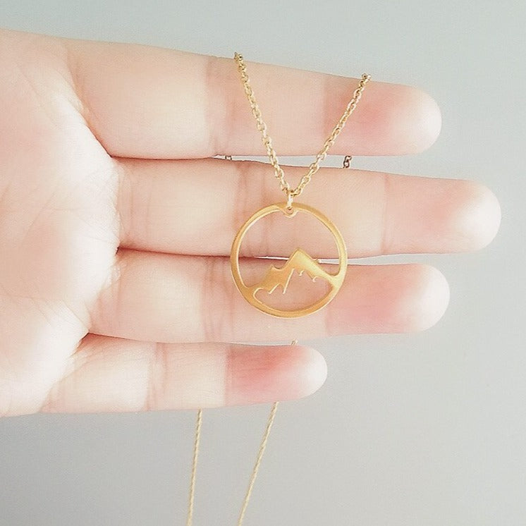 Damsmycke med bergsdesign i guld, elegant symbol för frihet och styrka. Vattentåligt halsband.