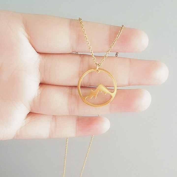 Damsmycke med bergsdesign i guld, elegant symbol för frihet och styrka. Vattentåligt halsband.