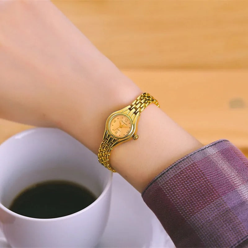 Exklusiv damklocka i guld, elegant accessoar för kvinnor. Fyrkantig miniklocka i slitstarkt stål.