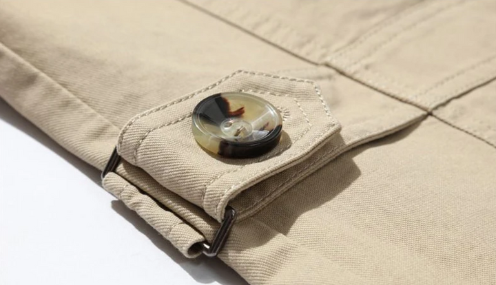 Detaljerad bild av dubbelknäppt trenchcoat för män med strukturerade axlar och krage.
