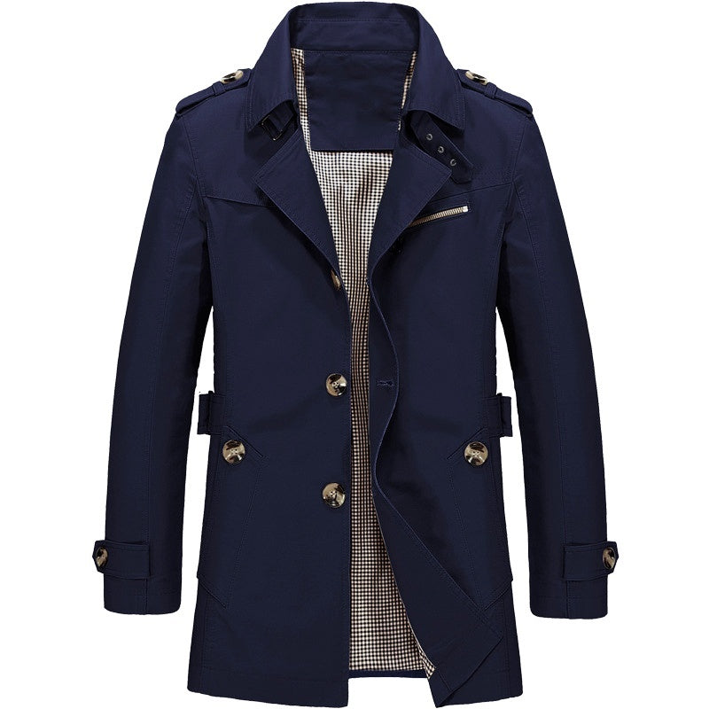 Närbild på tyget av en dubbelknäppt herr trenchcoat, visande dess strukturerade kvalitet.