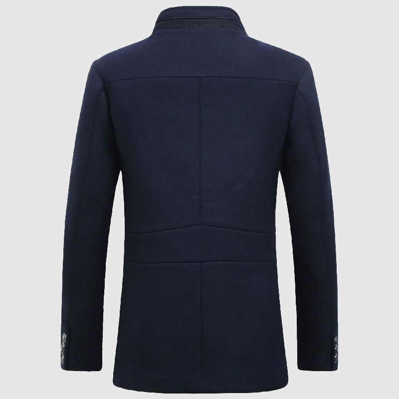 Man bär en elegant herrkappa med ståkrage och rutigt foder. Stilrent ytterplagg för herrmode under höst/vinter.
