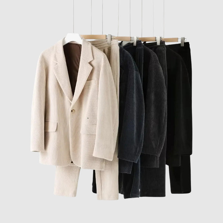 Man bär en komplett brun enkelknäppt manchesterkostym med hackad krage. Passar en elegant, modern look.