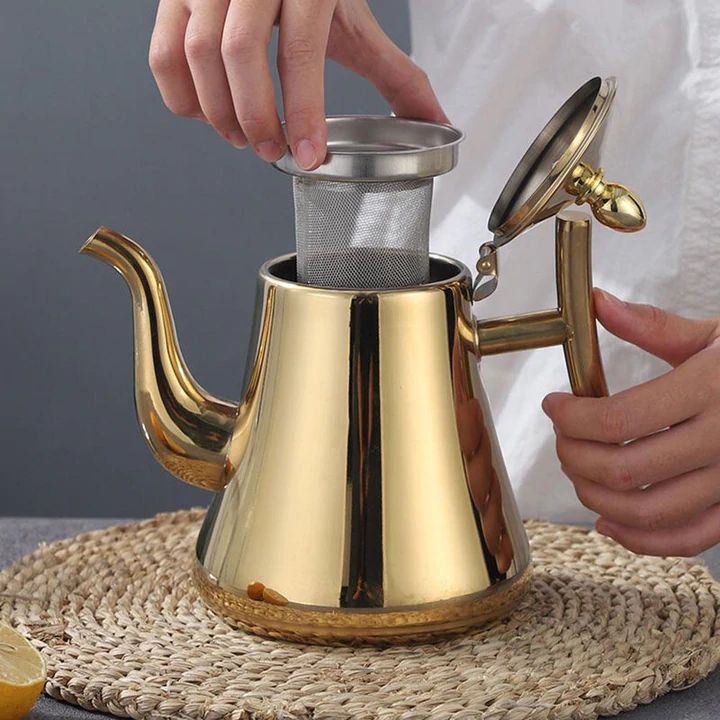 Närbild av rostfri induktionsvattenkokare med synligt filter och ergonomiskt handtag för enkel användning.
