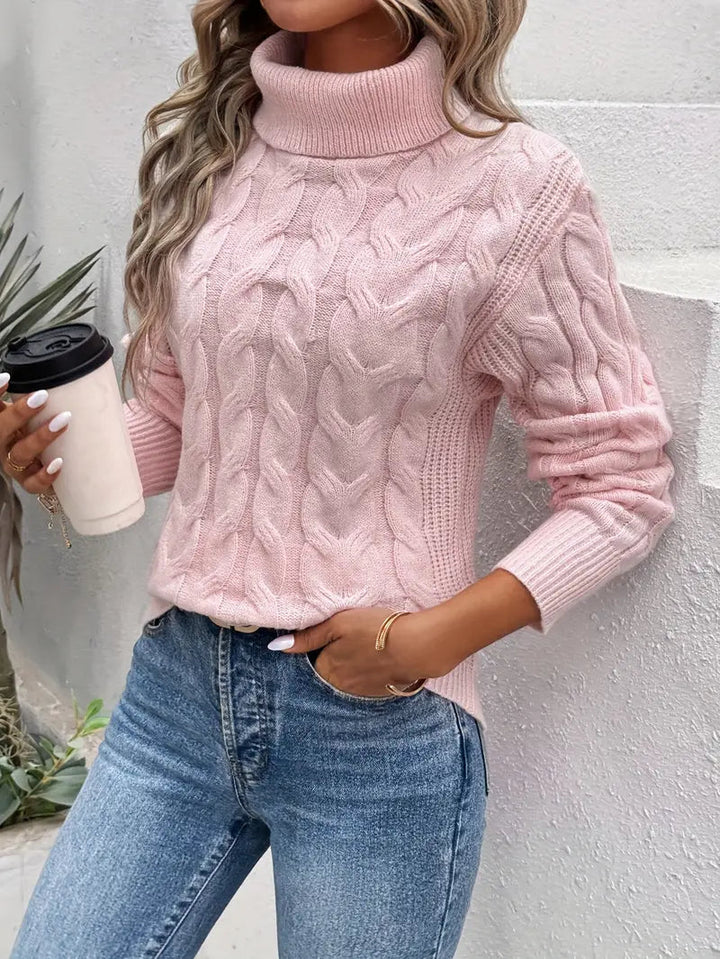 Detaljbild av kabelmönstrad damtröja med turtleneck. Klassisk stil, perfekt för kyliga dagar.