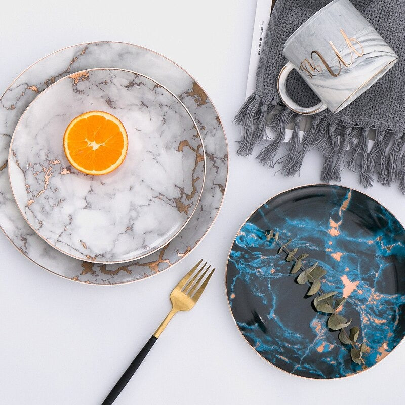 Modern keramiktallrik med tidlös marmorlook och guldaccenter, perfekt för det medvetna hemmet.