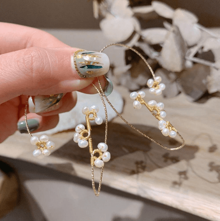 Eleganta damaccessoarer: blomsterkonst klippörhängen, en chic öronmanschett för speciella event.