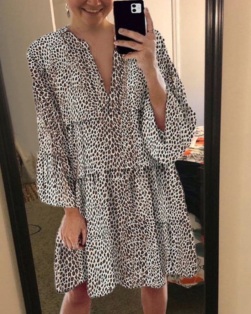 Trendig sommarklänning med leopardsmönster, V-hals och snygga puffärmar för en chic look.