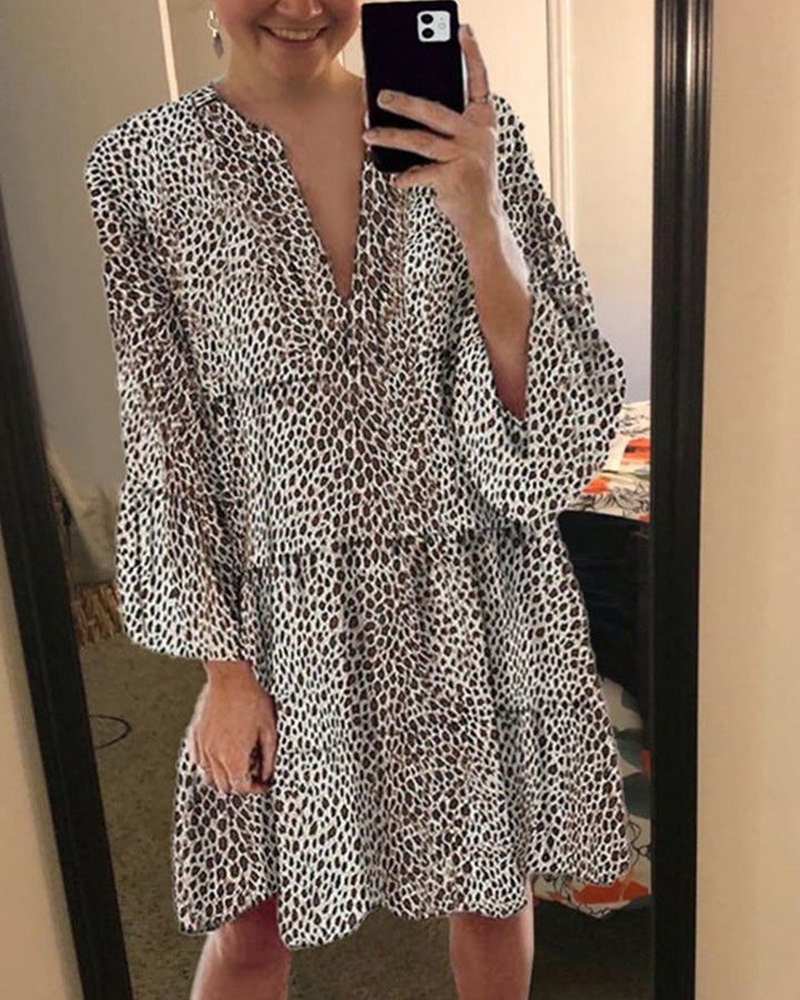 Trendig sommarklänning med leopardsmönster, V-hals och snygga puffärmar för en chic look.
