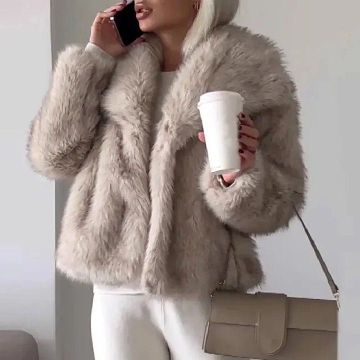 Kvinna bär elegant kort damjacka. Fluffig och varm vinterjacka, stilren för fest och vardag.