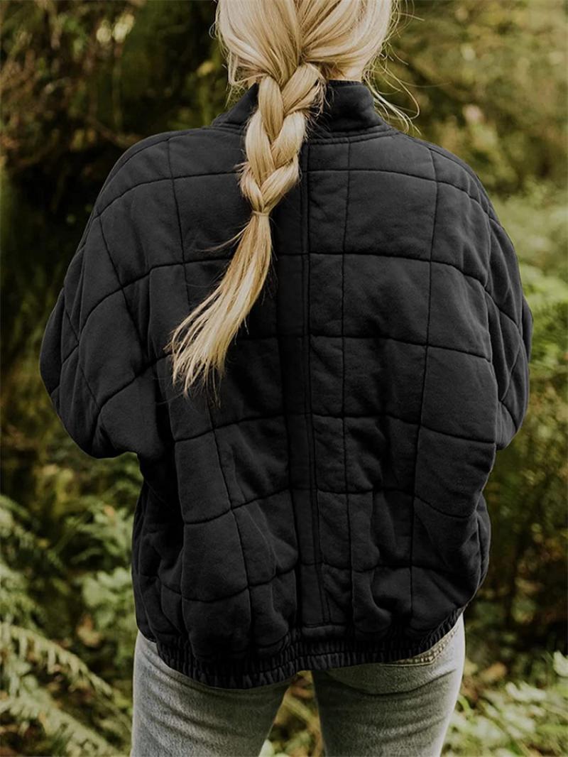 Närbild på den eleganta kviltningen på damjackan; visar sömmar och material.