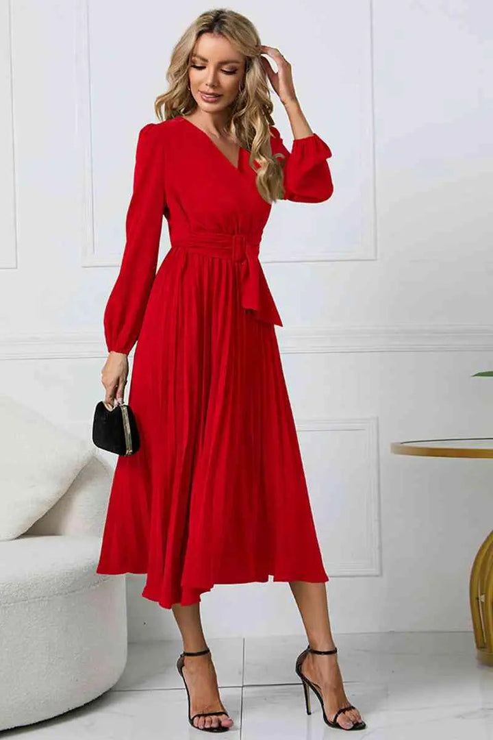 Veckad klänning stylad med accessoarer, en mångsidig outfit för formella tillfällen.