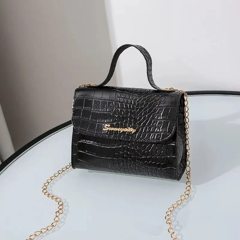 Chic miniväska med guldfärgad kedja. Trendig damväska, perfekt accessoar för en elegant look.