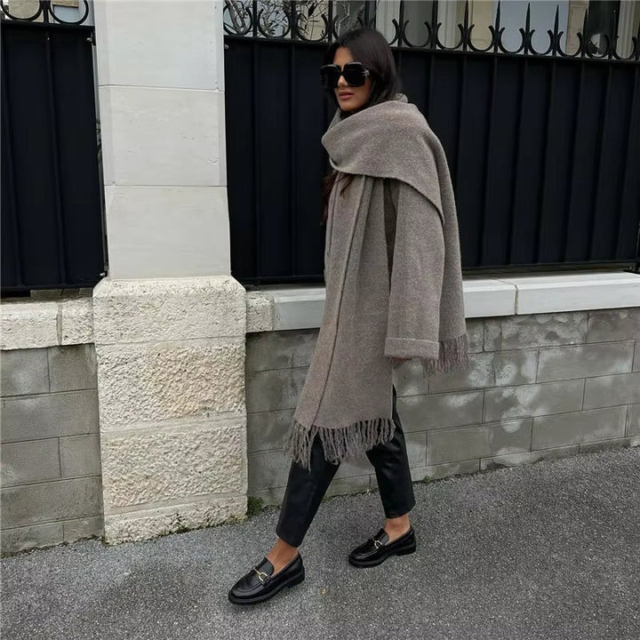 Stilren kvinnors vinterkappa i mjukt material. Integrerad sjal ger extra värme och en elegant look.