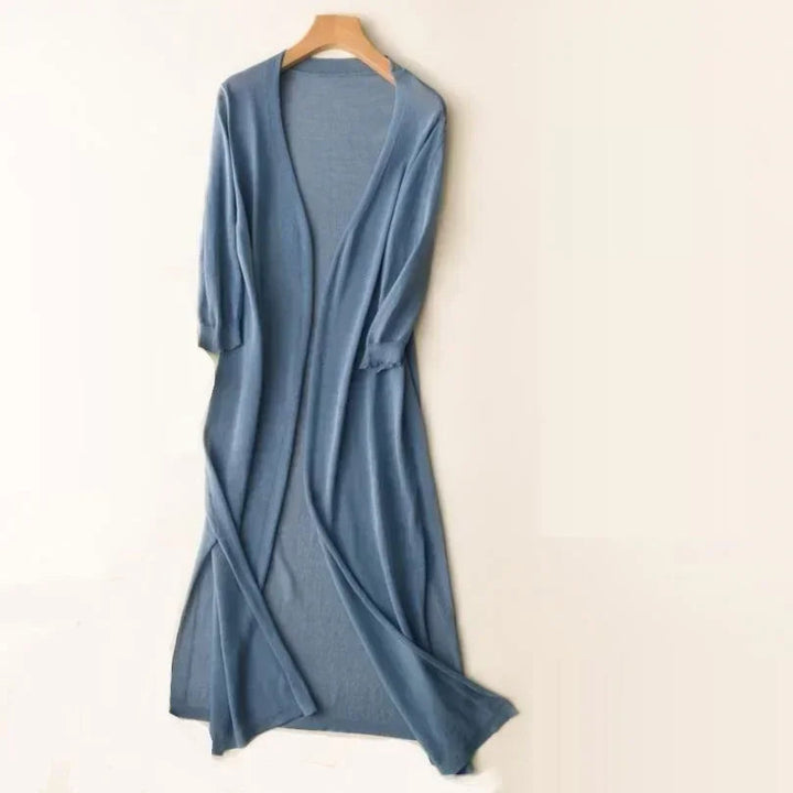 Kvinna visar upp flödande lång cardigan med öppen front. Elegant mode för damkläder i avslappnad stil.