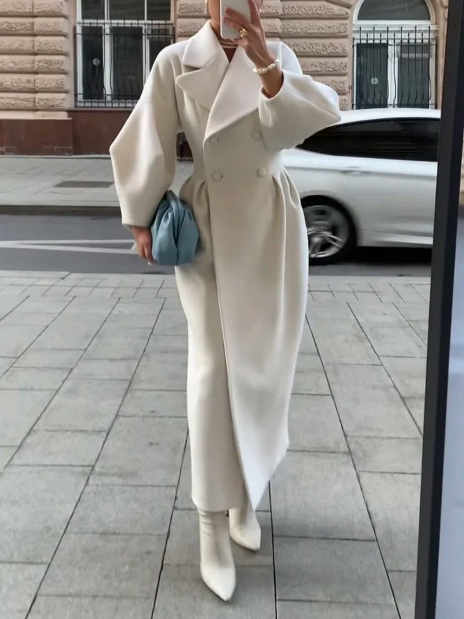 Elegant lång damkappa i klassisk ullblandning, perfekt för stiliga vinterdagar. Har synliga knappar.