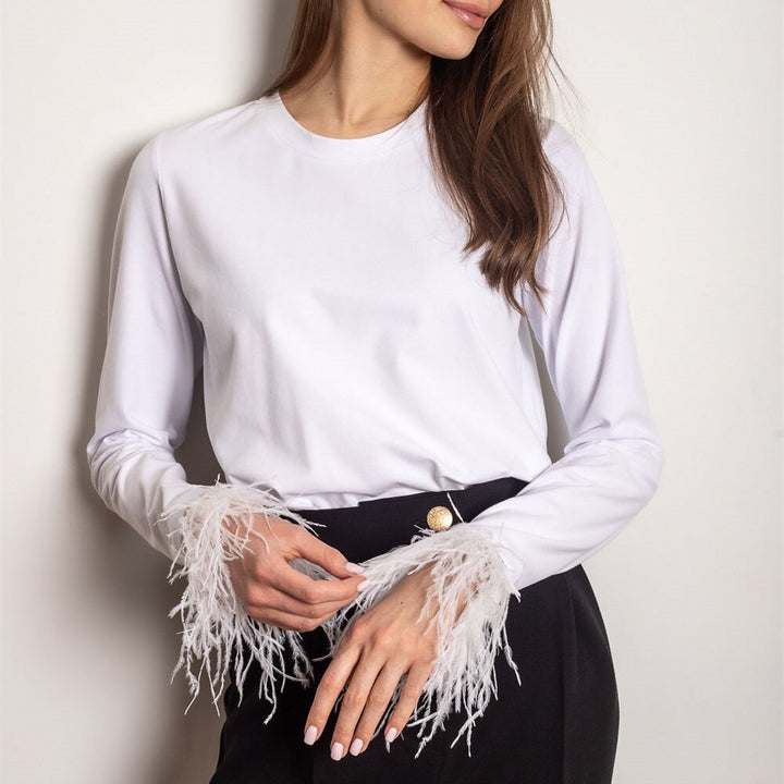 Modern långärmad damskjorta med snygga fjäderdetaljer. Mångsidig och bekväm för att skapa en chic look.