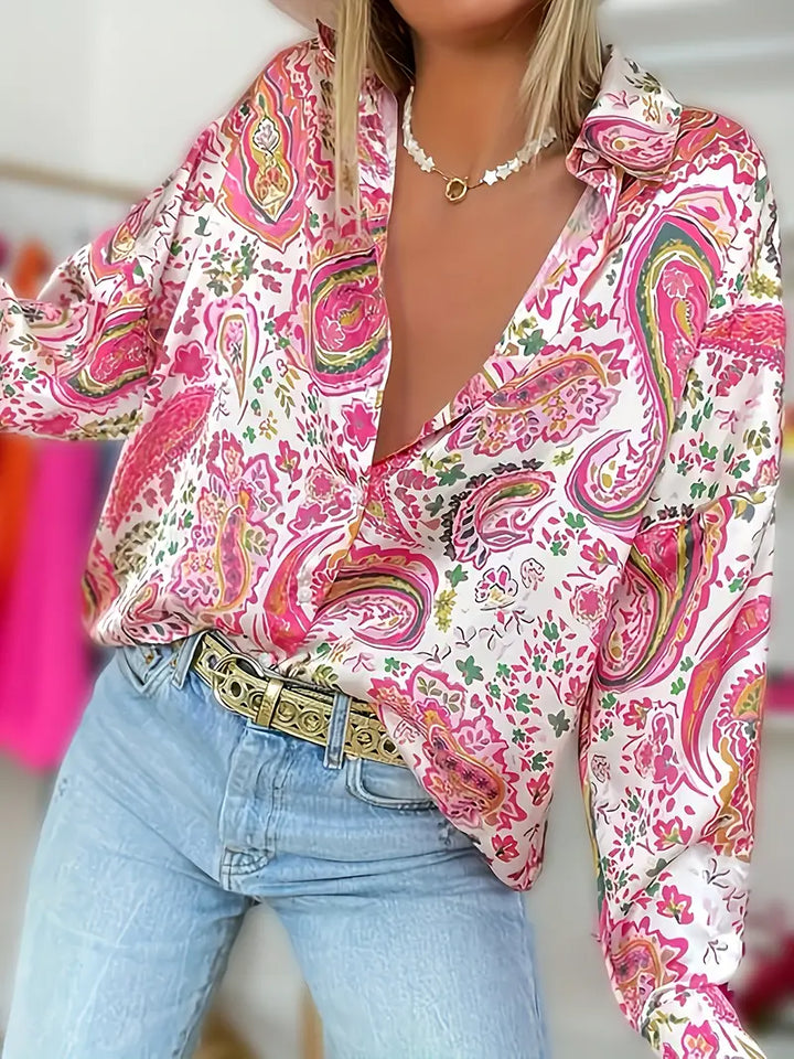 Elegant långärmad kvinnoskjorta med vackert paisley-tryck i rosa och blått, perfekt för stilfull vardagsmode.