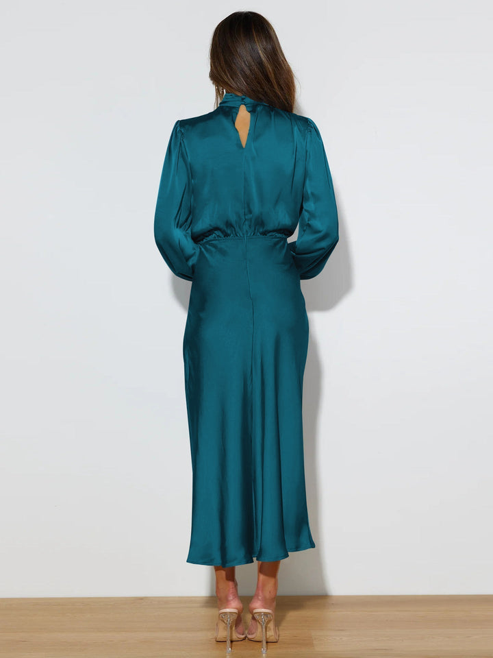 Lyxig aftonklänning i satin med långa ärmar. Elegant damkläder för fest och speciella tillfällen.