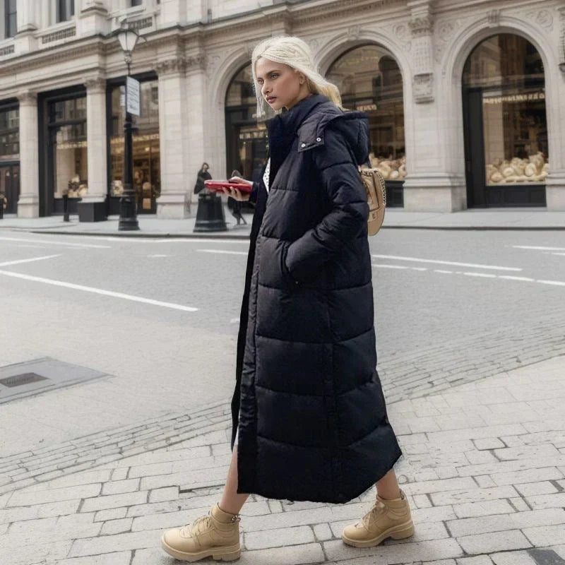 Lång dam vinterjacka i elegant polyestertyg, anpassad för optimal värme i kallt klimat.