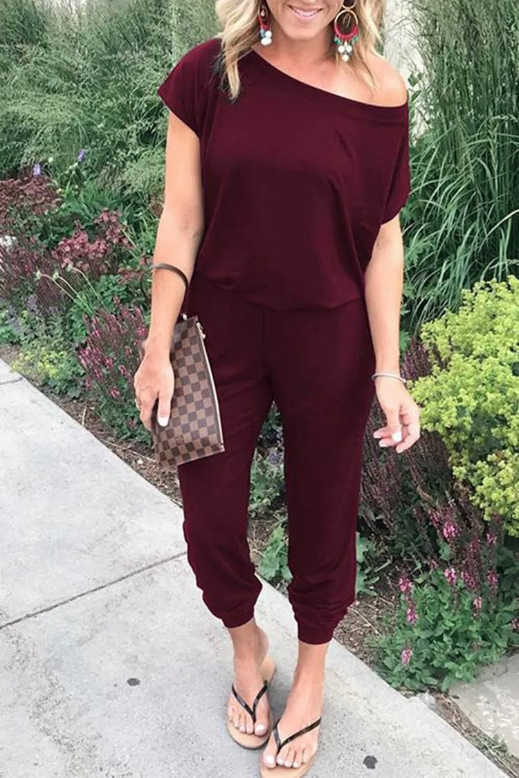 Modern damjumpsuit med unikt axelavslut. Luftig lös passform för en avslappnad men sofistikerad stil.