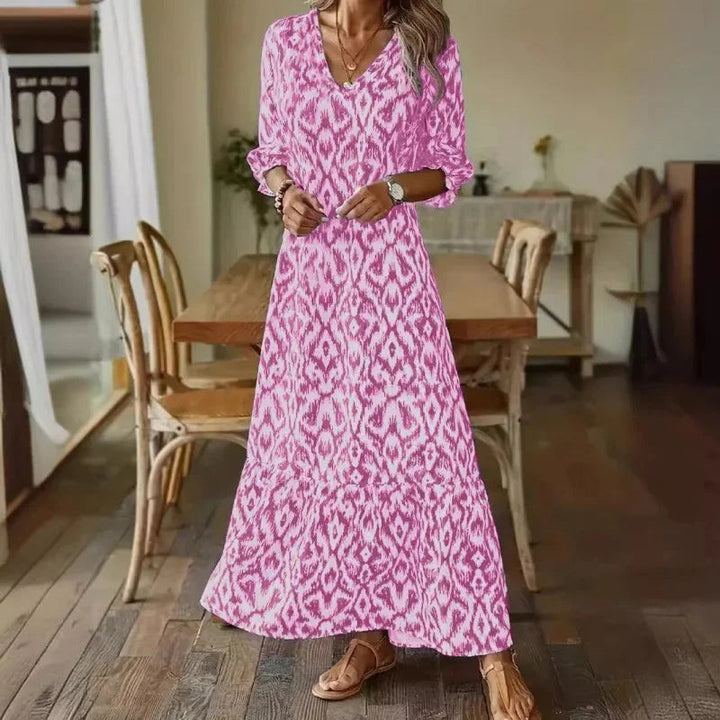 Trendig svart/vit mönstrad damklänning med V-hals och långa ärmar, en stilren sommarlook.