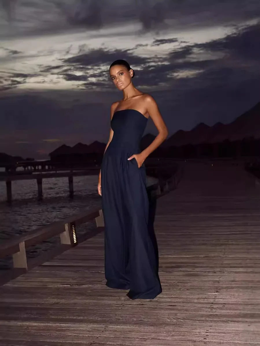 Stilren strapless byxdress för dam i mörkblått, med vida ben för en bekväm och elegant sommaroutfit.