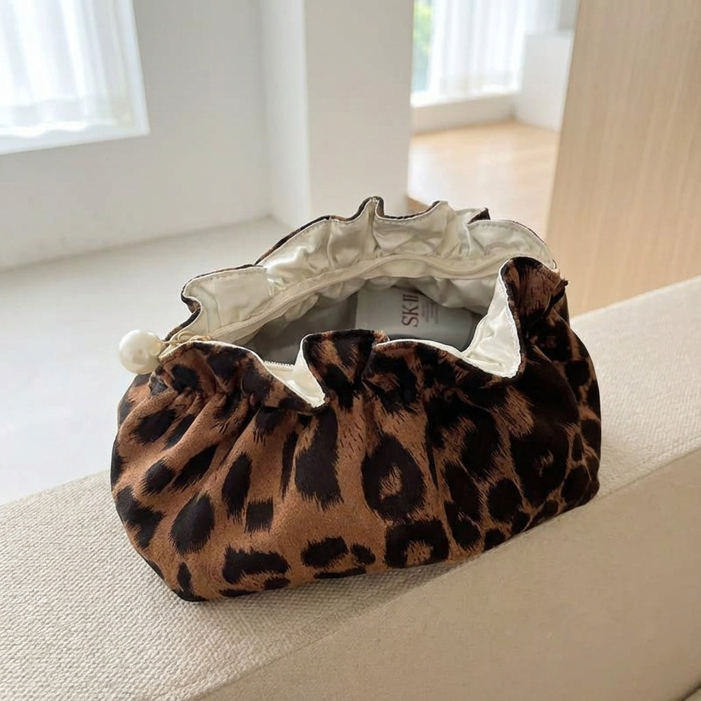 Lyxig sminkväska Pearlynn med leopardmönster och pärldetaljer. Elegant förvaring för skönhetsprodukter.