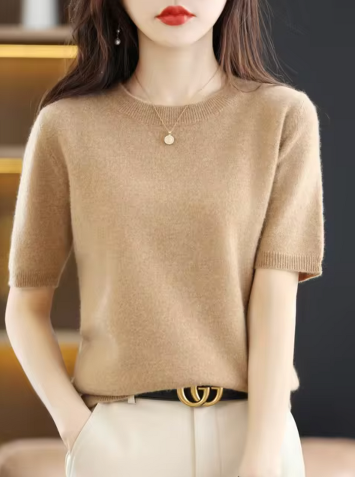 Kvinnlig modell bär en snygg beige kortärmad ull-kashmir tröja, poserande elegant