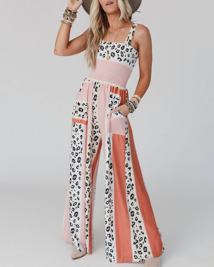 Elegant orange dam jumpsuit med breda ben och spaghettiband. Perfekt för fest eller stilren vardagslook. Bekväm.