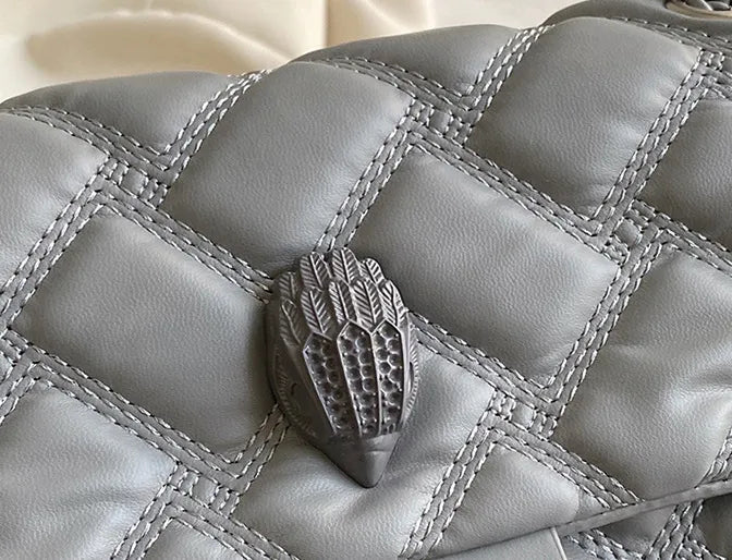 Elegant quiltad modeväska för damer, komplett med en iögonfallande örndetalj.