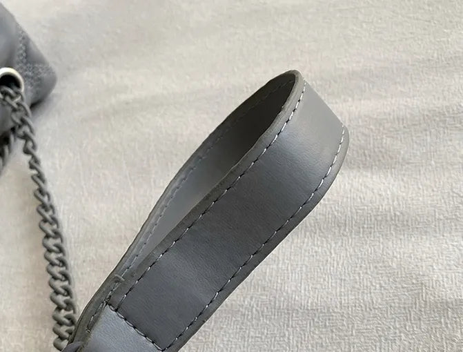 Stilren svart quiltad axelremsväska med en detaljerad örndesign, en tidlös handväska.
