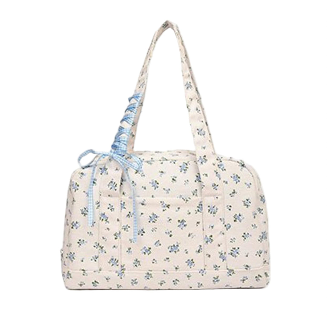 Blå duffelväska i canvas, stor och praktisk. Med rosett för en elegant och feminin touch.
