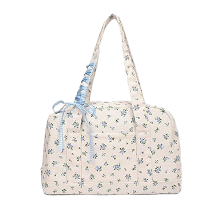 Blå duffelväska i canvas, stor och praktisk. Med rosett för en elegant och feminin touch.