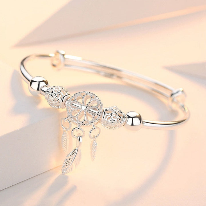 Dam drömfångare armband i silver med detaljerade fjädrar, ett elegant tillbehör.