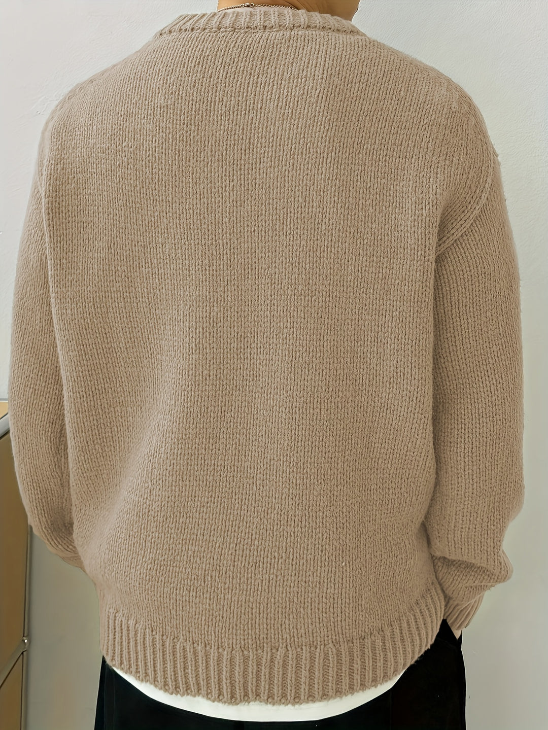 Herrtröja stylad för en avslappnad men elegant look, visar hur den mångsidiga tröjan passar till vardags.