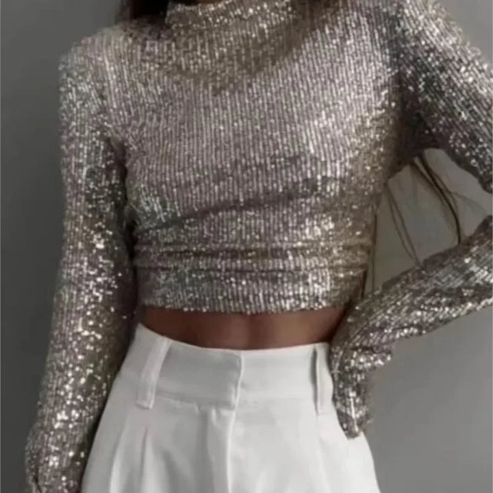 Elegant långärmad crop top i svart med paljetter, skapar en glamorös look för fest.