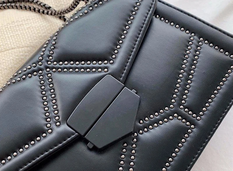 Svart crossbody väska för kvinnor med nitar och en snygg kedjerem, praktisk och chic.