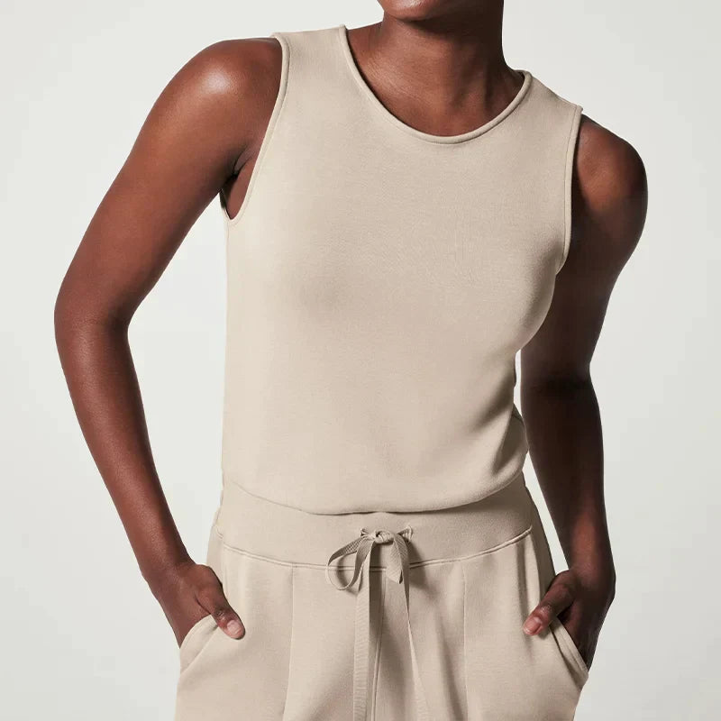 Smickrande beige dam jumpsuit med långa ärmar och elegant midjebälte, idealisk för festkläder.